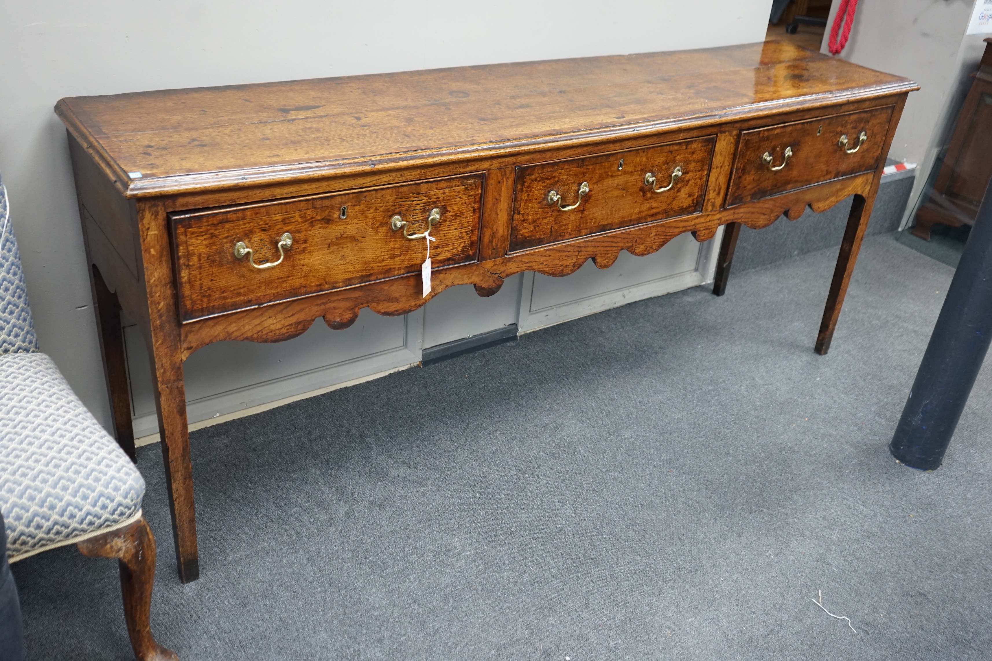 A George III provincial oak and mahogany banded low dresser with three drawers on square tapering legs, width 201cm, depth 46cm, height 83cm